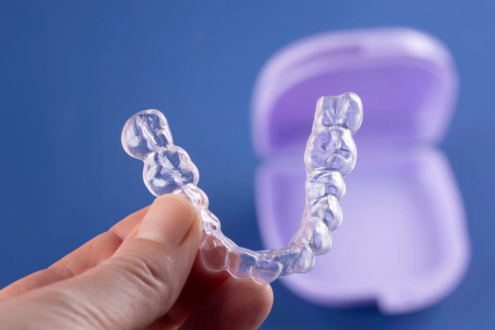 Invisalign-in-Canton-Michigan-with-blue-backgroud-and-purple-case