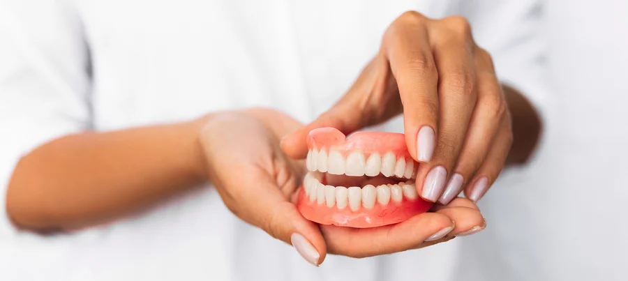 Dentist Holding Upper And Lower Dentures For Dentures Canton Michigan